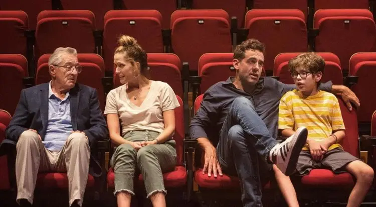 Four people sit in a movie theater.